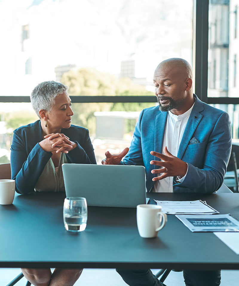 businessman and businesswoman talking over a computer